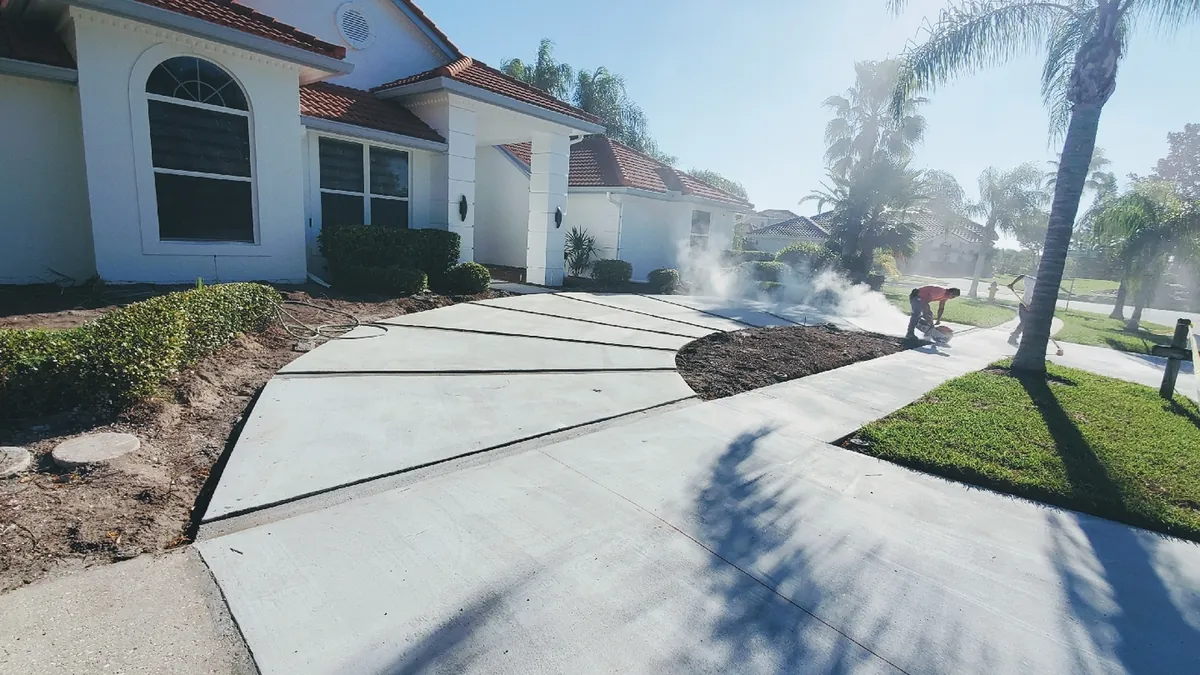A new concrete driveway in Tampa with the control joints being cut